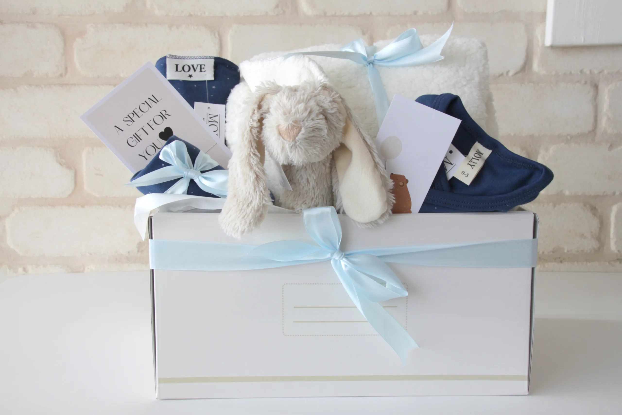 מתנה ליולדת הכוללת בגדי תינוקות מעוצבים, שמיכה חמה ורעשן אחיזה