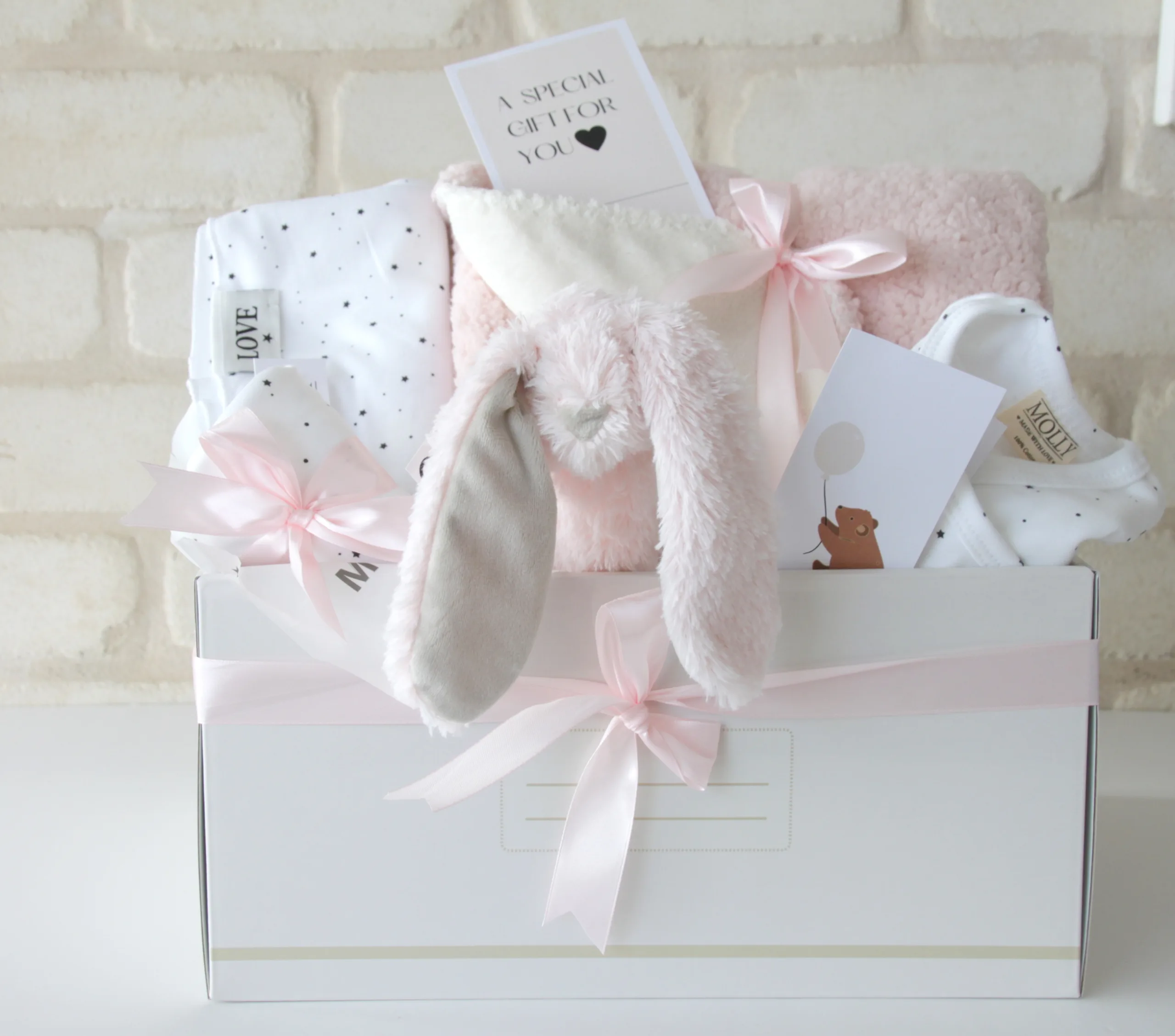 מתנה ליולדת הכוללת בגדי תינוקות מעוצבים, שמיכה חמה ורעשן אחיזה